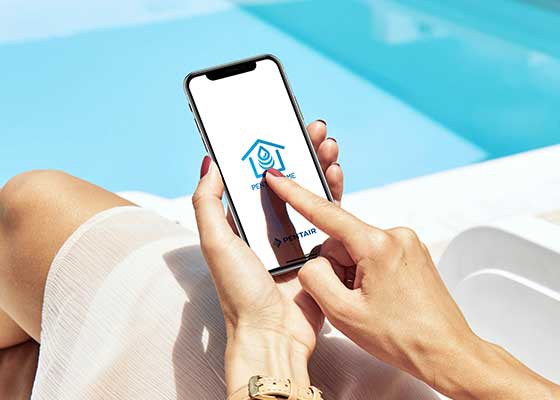 woman on phone next to clear blue pool with  Home app 